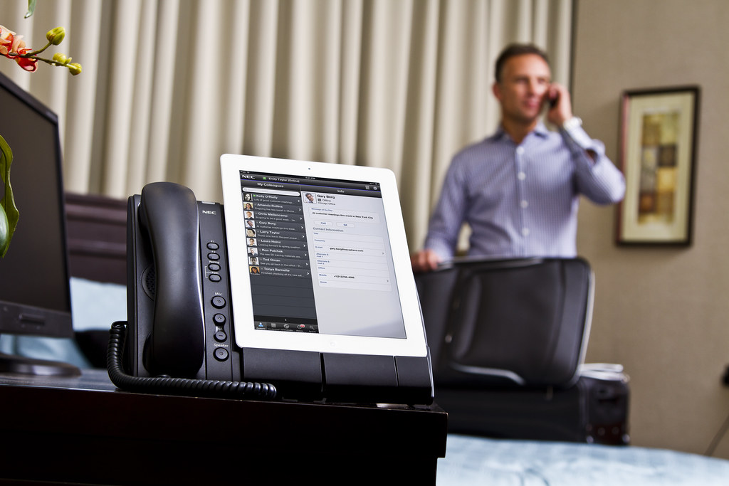 Man on a phone beside a desktop computer in an office